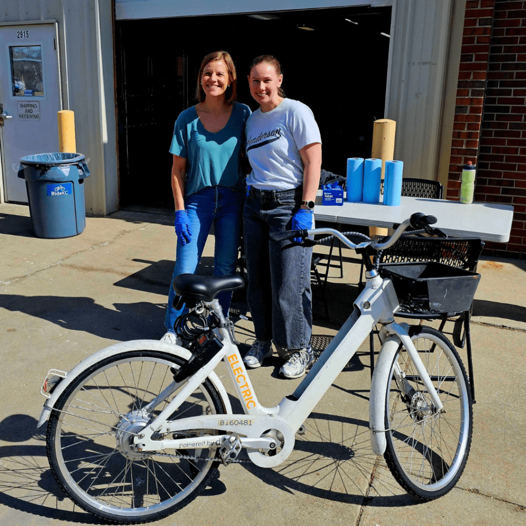 Volunteers from Henderson Engineering pose with a bike they're working on
