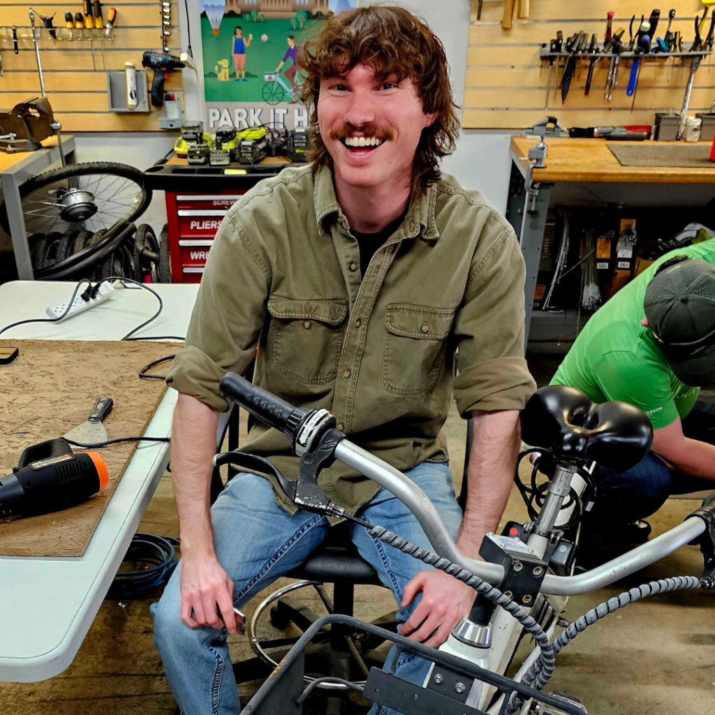 A Henderson Engineering volunteer works on a bike